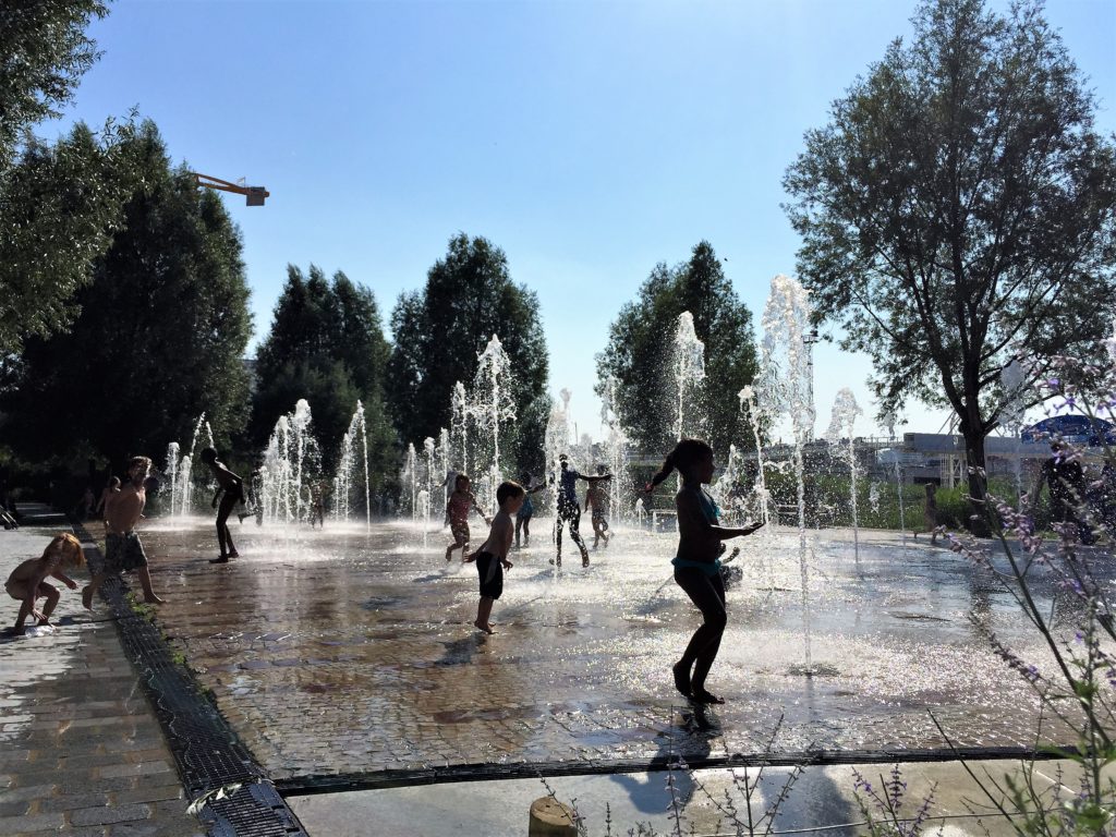 マーティン・ルーサー・キング公園の噴水で水浴びをする子供たち
